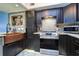 Copper farmhouse sink and dark cabinetry in updated kitchen at 9487 Tara Cay Ct, Seminole, FL 33776