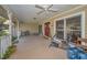 Spacious front porch featuring double doors, potted plants, and a ceiling fan at 1055 Riverside Ridge Rd, Tarpon Springs, FL 34688