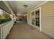 Spacious front porch with a ceiling fan, tiled floor, seating, and multiple entry doors for enjoying outdoor relaxation at 1055 Riverside Ridge Rd, Tarpon Springs, FL 34688