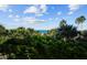 Partial view of the ocean with tropical foliage in the foreground at 1200 Gulf Blvd # 206, Clearwater Beach, FL 33767