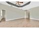 Tile-floored living room with high tray ceiling and ceiling fan at 12119 Hunters Lake Dr, New Port Richey, FL 34654