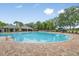 Circular community pool with lounge chairs, an umbrella, and a pool house at 13668 Newbridge St, Spring Hill, FL 34609