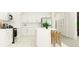 Modern white kitchen with island, stainless steel appliances, and light wood floors at 15129 Rainbow Quartz St, Wimauma, FL 33598