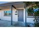 Covered entryway with a gray front door, white exterior, and updated windows at 1536 77Th N Ave, St Petersburg, FL 33702