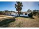 Single-story home with a driveway, fresh landscaping, and a palm tree in the yard at 1536 77Th N Ave, St Petersburg, FL 33702