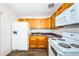Compact kitchen with white appliances, wood cabinets, and granite countertops at 1536 77Th N Ave, St Petersburg, FL 33702