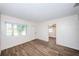 Living room space with wood-look tile flooring, white walls, and windows at 1536 77Th N Ave, St Petersburg, FL 33702