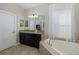 Modern bathroom with dark wood cabinets, a large soaking tub, and tile flooring at 19218 Alexandrea Lee Ct, Land O Lakes, FL 34638