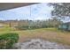 Tranquil backyard with a pond view, lush greenery, and a charming wind chime at 2003 Halmrock Pl, Sun City Center, FL 33573