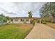 One-story home with landscaped yard, attached carport, and paved driveway at 2003 Halmrock Pl, Sun City Center, FL 33573