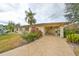 Front exterior of home with covered carport and lush landscaping at 2003 Halmrock Pl, Sun City Center, FL 33573