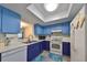Updated kitchen featuring blue cabinetry, white appliances, and wood-look flooring at 2003 Halmrock Pl, Sun City Center, FL 33573