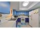 Compact kitchen with blue cabinets, white appliances, and light wood-look flooring at 2003 Halmrock Pl, Sun City Center, FL 33573