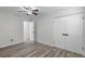 Bright bedroom with wood-look tile floors, ceiling fan, and white double closet doors at 2461 61St N Ln, St Petersburg, FL 33710