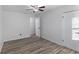 Bright bedroom with wood-look tile floors, ceiling fan, and white closet doors at 2461 61St N Ln, St Petersburg, FL 33710