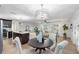 Dining area with a round table, white upholstered chairs, and a view of the living room and kitchen at 2461 61St N Ln, St Petersburg, FL 33710