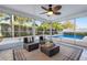 Enclosed patio with wicker furniture, ceiling fan, and a view of the backyard pool at 2461 61St N Ln, St Petersburg, FL 33710