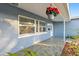 Charming front porch with hanging flower basket, white door, and blue siding at 2461 61St N Ln, St Petersburg, FL 33710