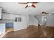 Open concept living room with wood flooring, ceiling fans, and a view of the kitchen at 3152 Royal Tuscan Ln, Valrico, FL 33594