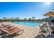 Relaxing community pool area with lounge chairs, umbrellas and tables, perfect for leisure at 37868 Beacon Brick Dr, Zephyrhills, FL 33540