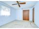 Simple bedroom with light blue walls, ceiling fan, and closet at 38916 11Th Ave, Zephyrhills, FL 33542