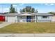 Charming light blue home with covered entryway, landscaped yard, and attached garage at 5047 Fitchburg Dr, Holiday, FL 34690