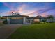 Charming single-Gathering home with a gray two-car garage and a landscaped front yard at sunset at 5101 Huntington Ne Cir, St Petersburg, FL 33703