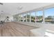 Sunroom with multiple windows overlooking waterfront canal, light floors and ceiling fans at 5101 Huntington Ne Cir, St Petersburg, FL 33703
