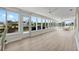 Sunroom with large windows and sliding door overlooking waterfront canal, plus light floors and ceiling fans at 5101 Huntington Ne Cir, St Petersburg, FL 33703
