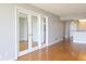 Open-concept living area with hardwood floors, grey walls, and glass paneled doors offers versatile living space at 7400 Sun Island Dr # 501, South Pasadena, FL 33707