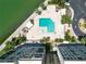 Aerial view of a community pool surrounded by lush landscaping and lounge chairs at 7400 Sun Island Dr # 501, South Pasadena, FL 33707