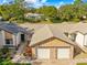 An aerial close-up of a charming villa-style home, showcasing its two-car garage and landscaping at 7497 Heather Walk Dr, Weeki Wachee, FL 34613