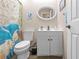 Clean bathroom with white vanity, toilet, and whimsical shower curtain at 7497 Heather Walk Dr, Weeki Wachee, FL 34613