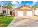 Brick front exterior of home with two-car garage and landscaped lawn at 7497 Heather Walk Dr, Weeki Wachee, FL 34613