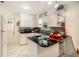 White kitchen with black countertops and island at 10708 Edgewater Ln, Tampa, FL 33612