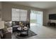 Comfortable living room with gray sectional sofa, coffee table, and sliding glass doors at 11746 Blackbrook Ct, Seffner, FL 33584