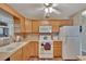 Kitchen with wood cabinets, white appliances, and ample counter space at 1601 W Del Webb Blvd, Sun City Center, FL 33573