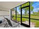 Screened balcony overlooking lush landscaping and a waterway at 1700 Cove Ii Pl # 310, Sarasota, FL 34242