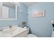 Guest bathroom with updated vanity, toilet, and blue walls at 1700 Cove Ii Pl # 310, Sarasota, FL 34242