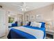 Cozy bedroom with blue bedding, ceiling fan, and sliding mirror closet doors at 1700 Cove Ii Pl # 310, Sarasota, FL 34242