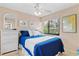 Comfortable bedroom with blue bedding, ceiling fan, and wicker furniture at 1700 Cove Ii Pl # 310, Sarasota, FL 34242