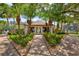 Clubhouse exterior with palm trees, landscaped gardens, and a brick pathway at 1700 Cove Ii Pl # 310, Sarasota, FL 34242