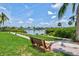 Scenic waterfront view with a park bench, lush greenery, and boats in the background at 1700 Cove Ii Pl # 310, Sarasota, FL 34242