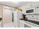 Kitchen featuring white appliances, white cabinets, and granite countertops at 1700 Cove Ii Pl # 310, Sarasota, FL 34242