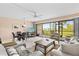 Open living room with dining area, comfortable seating, and sliding glass doors to the balcony at 1700 Cove Ii Pl # 310, Sarasota, FL 34242