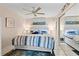 Inviting main bedroom with king-size bed, ceiling fan, and mirrored closet doors at 1700 Cove Ii Pl # 310, Sarasota, FL 34242