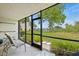 Relaxing screened porch with seating, lush greenery, and waterfront views at 1700 Cove Ii Pl # 310, Sarasota, FL 34242