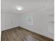 Bright bedroom with wood-look flooring, window, and built-in shelves at 1708 E Poinsettia Ave, Tampa, FL 33612