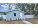 Charming light blue home with white fence and landscaping at 1708 E Poinsettia Ave, Tampa, FL 33612