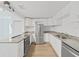 Bright and open kitchen with white cabinetry, stainless steel appliances, and granite countertops at 1708 E Poinsettia Ave, Tampa, FL 33612